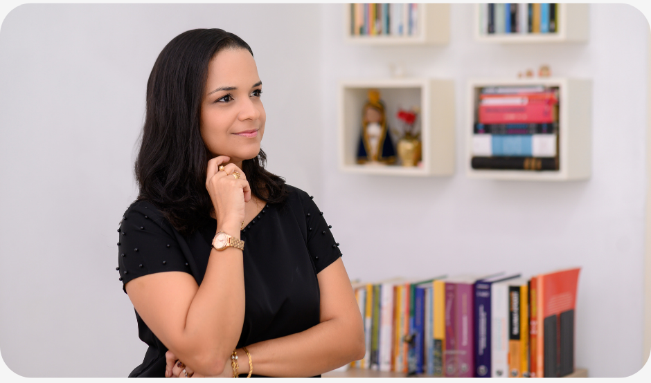 Daisy Rigo em seu consultório, ao lado de livros